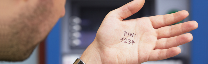 Man looks at PIN number written on hand