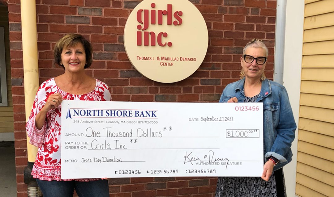 Photo of Liz White, NSB VP, presenting a $1,000 Jeans Day donation to Deb Ansourlian of Girls Inc.