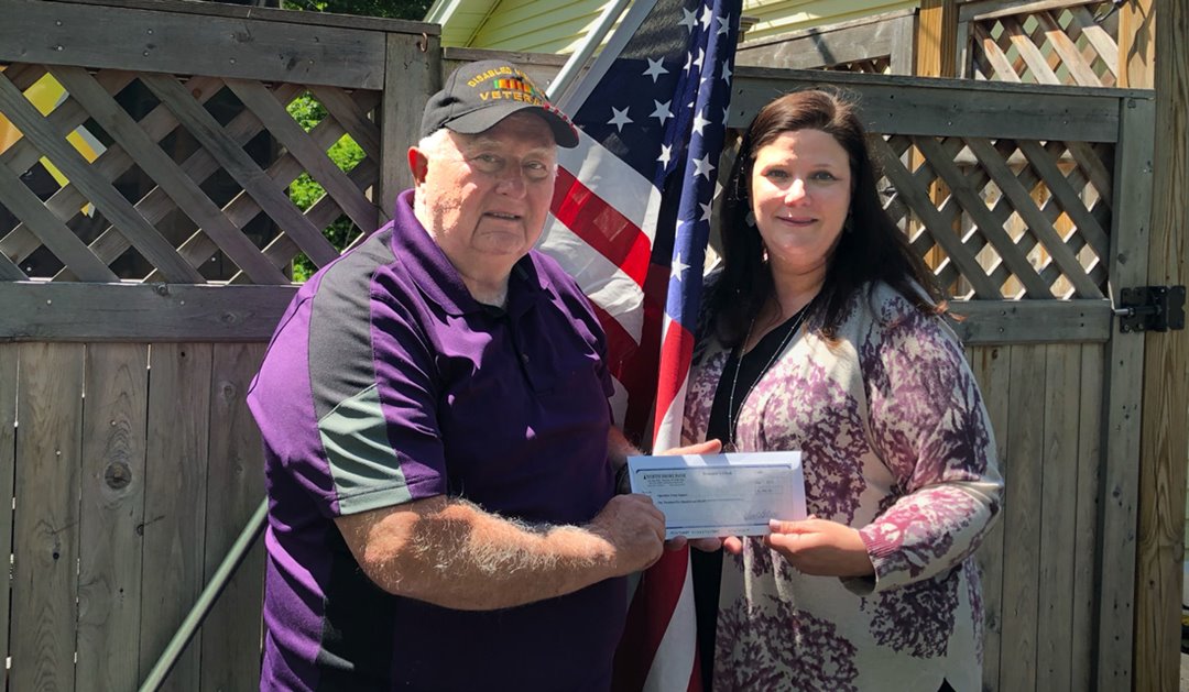 Photo of  Richard Moody, Founder of Operation Troop Support receives a $1,500 donation from Jodi Houghton of North Shore Bank