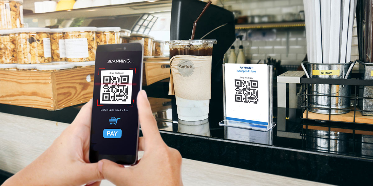 Image of someone using a QR code to purchase a cup of coffee