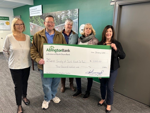 Five people standing next to a check for the Society of Saint Vincent De Paul. 