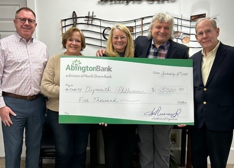 Group of people holding a large check for a donation to Plymouth Philharmonic