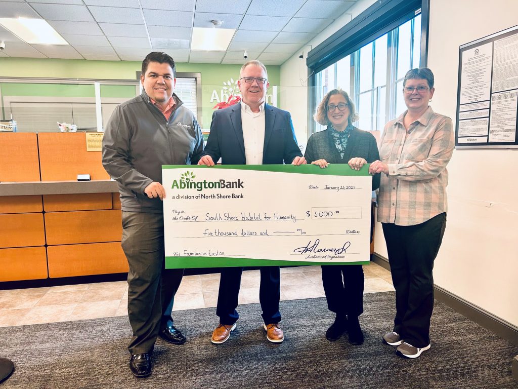 A group of people holding a check donation for Habitat for Humanity. 