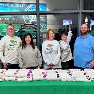 Employees hand out basketball shirts at a local fundraiser.