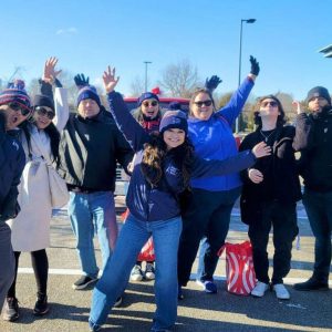 Bank employees outside with their arms raised smiling as they attend a local parade.