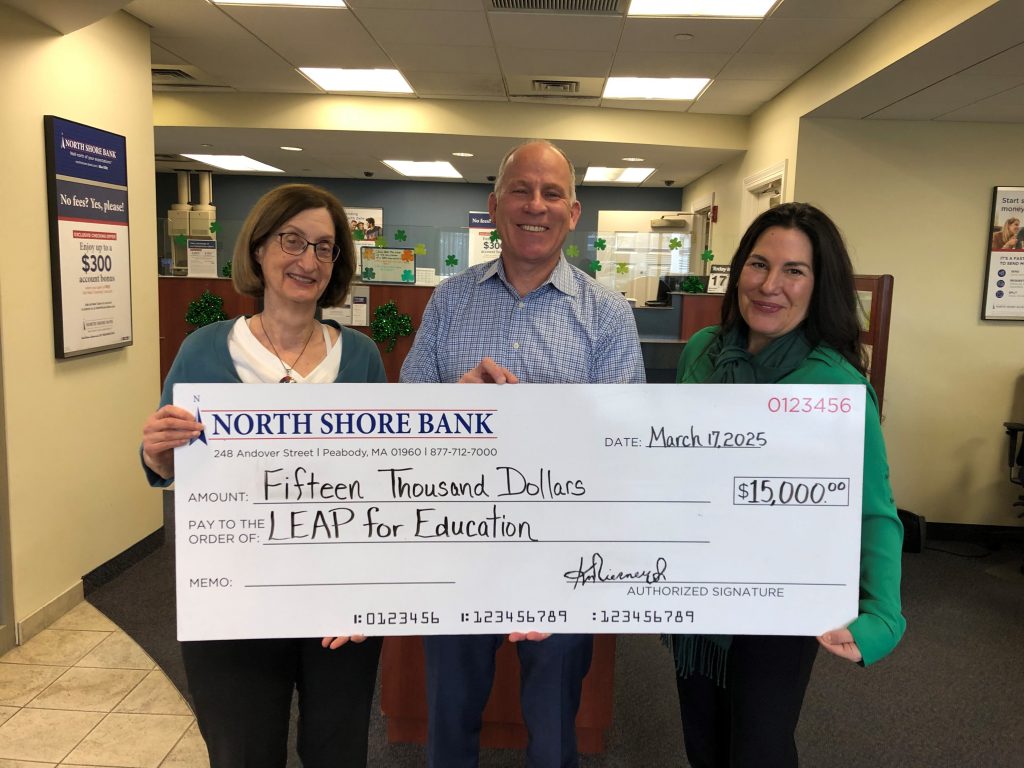 A group of bank employees holding a check presentation for LEAP for Education.