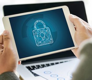 Hands holding a tablet displaying an image of a lock